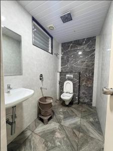 a bathroom with a toilet and a sink at Sathya Comforts in Bangalore +10 photos