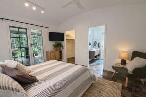 a bedroom with a bed and a chair and a bathroom at Private Rainforest Guesthouse in Doonan in Doonan