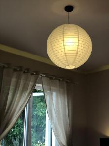 a ceiling with a lamp and a window with curtains at Nhà 5 PM in Da Thien
