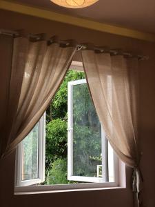 a window with curtains in a room at Nhà 5 PM in Da Thien