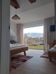 a bedroom with a bed and a large window at Chata Za Studeným potokom in Habovka