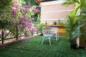 a patio with a table and chairs and flowers at Bougain Blossom Spacez Luxury Villa with Terrace Garden in Bangalore