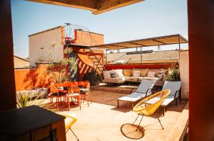 a patio with chairs and a couch and a table at Villa Troletti, hôtel particulier de luxe en Provence in L'Isle-sur-la-Sorgue
