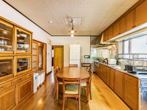 a large kitchen with a wooden table and chairs at The M HONMACHI in Nakatsugawa