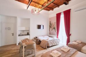 a bedroom with two beds and a table in it at Toto e Peppino Luxury Rooms in Naples