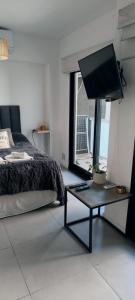 a bedroom with a bed and a table with a television at Depto H in Buenos Aires