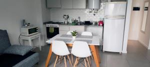 a kitchen with a table and four white chairs at Depto H in Buenos Aires