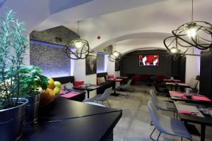 a dining room with tables and chairs and a tv at Hotel Ratuszowy in Chojnice