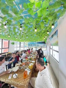 a group of people sitting at tables in a restaurant at VENUS HOTEL catba in Cat Ba