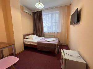a hotel room with a bed and a window at Гостиница TERRA in Almaty