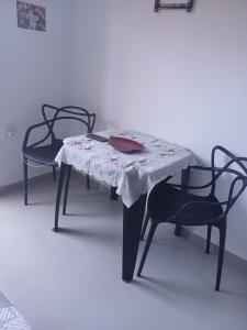 a table with two chairs and a table with a table cloth at Kitinete encantadora in Arraial do Cabo