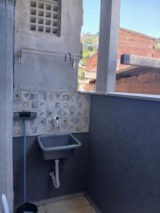 a bathroom with a sink and a window at Kitinete encantadora in Arraial do Cabo +13 photos