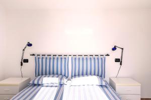a bedroom with a bed with blue and white stripes at Albarella Family Villa with Private Pool and Garden in Isola Albarella +47 photos