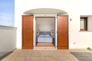 a door leading into a bedroom with a bed at Albarella Family Villa with Private Pool and Garden in Isola Albarella
