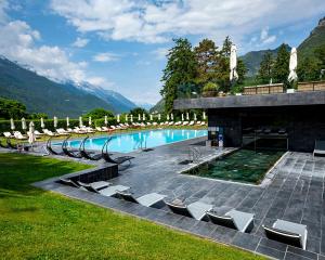 a swimming pool with lounge chairs and umbrellas at Parc Hotel Billia in Saint Vincent