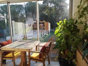 a dining room with a table and a large window at Villa la Roseraie chambre avec sdb privée in Montpellier