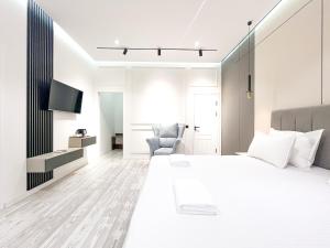 a white bedroom with a large bed and a chair at AYUB Modern & Heritage HOTEL in Bukhara +61 photos