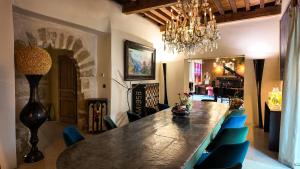 a dining room with a long table and blue chairs at Villa Troletti, hôtel particulier de luxe en Provence in L'Isle-sur-la-Sorgue