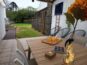a wooden table with a vase with orange juice at H2Furnas Natur in Furnas
