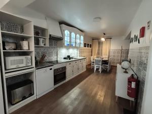 a kitchen with white appliances and a dining room at H2Furnas Natur in Furnas
