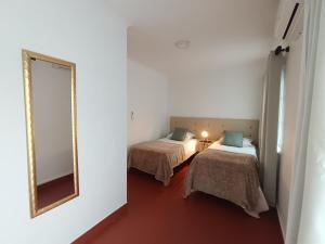a room with two beds and a mirror at H2Furnas Natur in Furnas +36 photos