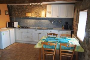 a kitchen with a table and chairs and a kitchen with white cabinets at Ingerichte safaritent in Saint-Priest-en-Murat