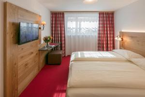 um quarto de hotel com uma cama e uma televisão em Annex Antika em Zermatt