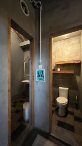 a bathroom with a toilet and a sign on the door at Shelter Hostel Malang in Malang