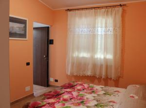a bedroom with a bed with pink flowers on it at Agrimar in Magliano Romano