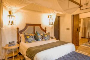 a bedroom with a large bed in a room at Mbano Manor Hotel Victoria Falls in Victoria Falls +106 photos