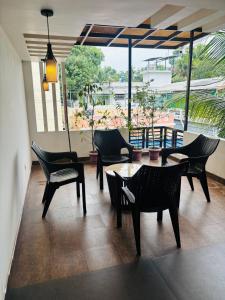 a living room with chairs and tables and a large window at Love shore in Cochin