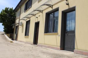 a yellow building with a black door and windows at Agrimar in Magliano Romano