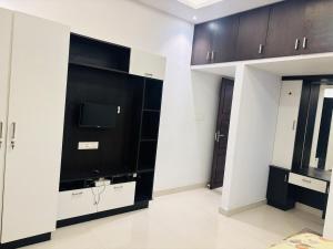 a living room with a tv and black cabinets at Love shore in Cochin