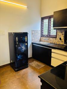 a kitchen with a refrigerator with a painting on it at Love shore in Cochin +5 photos