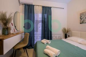 a bedroom with a bed and a desk and a mirror at Markella Lux Apartment in Alexandroupoli