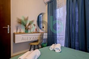 a room with a bed with two pairs of slippers at Markella Lux Apartment in Alexandroupoli