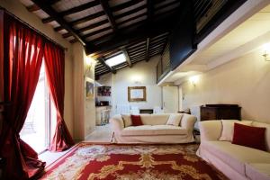a living room with two white couches and a red curtain at LM Suites Spagna in Rome
