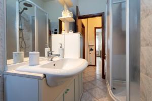 a bathroom with a white sink and a shower at Bicocca Urban Suite - SELF CHECKIN WIFI in Novara +25 photos