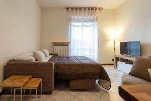 a living room with a bed and a couch at Bicocca Urban Suite - SELF CHECKIN WIFI in Novara
