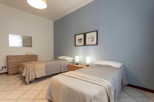 a room with two beds and two lights on the wall at Bicocca Urban Suite - SELF CHECKIN WIFI in Novara