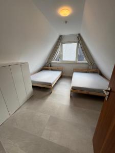 a room with two beds and a window at Eulenburg am Reuthsee Nurdachhaus mit Garten in Sulzdorf an der Lederhecke