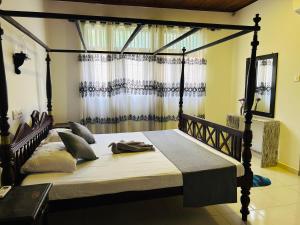 a bedroom with a large bed with a wooden frame at VILLA No34 HIKKADUWA in Hikkaduwa