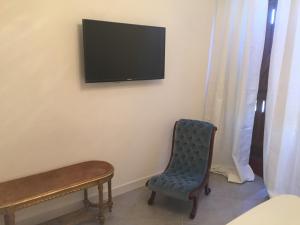 a room with a chair and a television on a wall at Nel Sole di Daniel in San Felice Circeo
