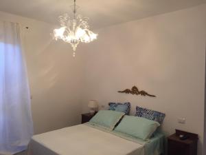 1 dormitorio con cama y lámpara de araña en Nel Sole di Daniel, en San Felice Circeo