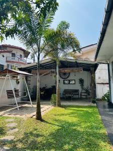 a patio with two palm trees next to a house at VILLA No34 HIKKADUWA in Hikkaduwa