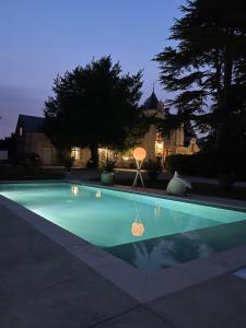 a swimming pool in front of a house at night at Studio Charmant au Château Leugny in La Celle-sous-Gouzon