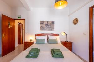 a bedroom with a bed with two green pillows on it at Hospedaria Portuguesa in Alpiarça