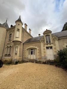 an old house with a large driveway in front of it at Studio Charmant au Château Leugny in La Celle-sous-Gouzon