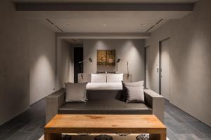 a bedroom with a bed and a wooden table at Shizuru 鴨川 ""旧SGR鴨川"" in Kyoto