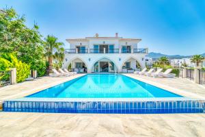 a swimming pool in front of a villa at Carrington Holidays in Kyrenia